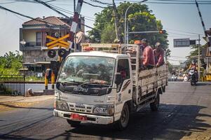 grupp av projekt arbetare ridning i de tillbaka av ett isuzu lastbil som tillhör till de satgas, Indonesien, 28 oktober 2023. foto