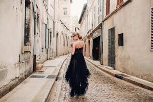 en eleganta brud i en svart bröllop klänning poser i de gammal franska stad av avignon. modell i en skön svart klänning. Foto skjuta i provence.