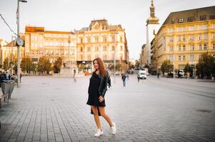 eleganta ung flicka i en svart klänning och jacka i de gammal stad av brno. tjeck foto