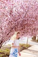 flicka bland skön körsbär blommar i full blomma foto