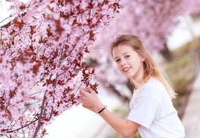 flicka bland skön körsbär blommar i full blomma foto