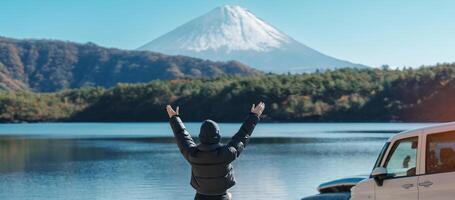 kvinna turist njut av med fuji berg på sjö saiko, Lycklig resande sightseeing montera fuji och väg resa fuji fem sjöar. landmärke för turister attraktion. japan resa, destination och semester foto