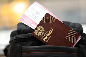 röd portugal pass av europeisk union med flygbolag biljetter på turistiska ryggsäck foto