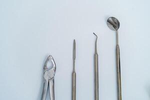 dental verktyg uppsättning. mun spegel, periodontal explorer scaler, tand extrahera tång, tång, sax. dental Utrustning på vit bakgrund. närbild. foto