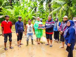 pariaman, indonesien - Mars 8, 2024. herr. regional sekreterare av pariaman stad händer över mat hjälpa till översvämning offer i norr pariaman distrikt foto