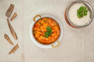 jhinga jalfrezi eller räkor jalfrezi med vit ris eras i en maträtt isolerat på tabell topp se av indisk kryddor mat foto