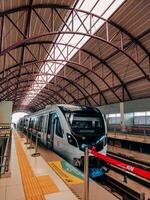palembang, Indonesien, juni 16, 2022. lrt tåg ankommer på en tåg station foto