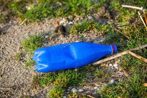 plast flaska på de Strand av de sjö. miljö- förorening. plast avfall på de strand. foto