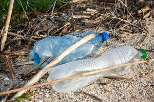 plast flaska på de Strand av de sjö. miljö- förorening. plast avfall på de strand. foto