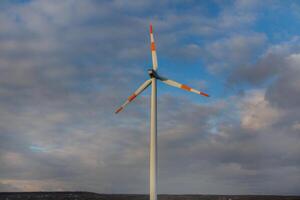 vind turbin på de bakgrund av de blå himmel. rena förnybar energi. elektrisk kraft produktion. foto