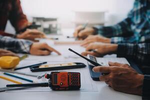 ingenjör människor möte arbetssätt och pekande på en ritningar i kontor för diskuterar. teknik verktyg och konstruktion begrepp. foto