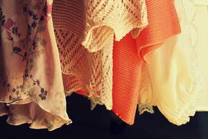 kvinnor kläder hängande på kuggstänger i en boutique Lagra foto