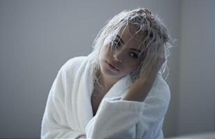 sexig blond flicka med våt hår i en morgonrock foto