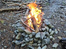 lågor av trä brand i de campingplats i sten brand grop i de skogar av Washington stat med en skön glöd och rök foto