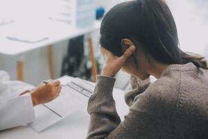 stänga upp allvarlig läkare bär medicinsk ansikte mask hört mogna kvinna patient på utnämning i kontor, läkare förklara behandling, ger rekommendationer, äldre generation sjukvård foto