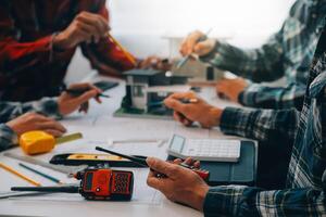 ingenjör människor möte arbetssätt och pekande på en ritningar i kontor för diskuterar. teknik verktyg och konstruktion begrepp. foto