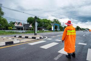 trafik officer bär orange regnkostnad med kontrollera och riktande trafik i landsbygden foto