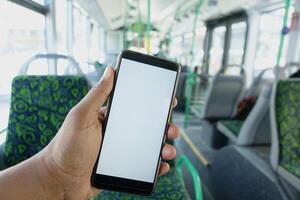 passagerare Sammanträde i en buss använder sig av hans telefon. foto