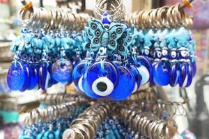 en knippa av blå ondska öga nyckelringar hängande på en hylla foto