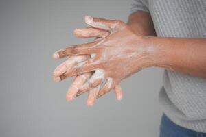 ung man tvättar händerna med tvål varmt vatten foto