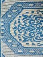 blå och vit vävd matta med motiv mönster på den foto