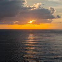ai genererad gyllene strålar av soluppgång målning de himmel och hav med värme för social media posta storlek foto