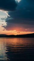 ai genererad solnedgång på de sjö utvecklas under dramatisk mörk moln vertikal mobil tapet foto