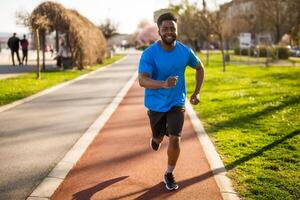 ung afrikan-amerikan man är joggning i de stad. foto