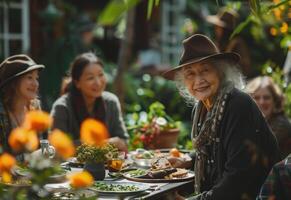 en glad senior mormor sitter omgiven förbi henne familj på ett utomhus- middag tabell. . foto