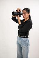 en professionell, självsäker asiatisk kvinna fotograf är tar bilder i en fotografering studio. foto