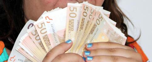 massor av euro pengar hölls förbi en hand tycka om en fläkt foto