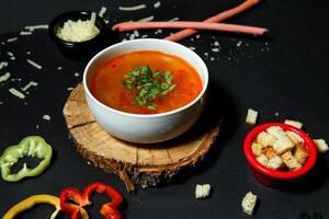 skål av tomat soppa på trä- styrelse foto
