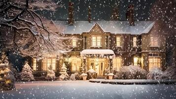 jul i de landsbygden herrgård, engelsk Land hus herrgård dekorerad för högtider på en snöig vinter- kväll med snö och Semester lampor, glad jul och Lycklig högtider foto