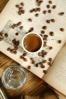 en kopp av kaffe på ett öppen bok foto