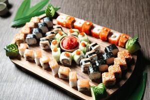 blandad sushi typer anordnad på trä- bricka foto