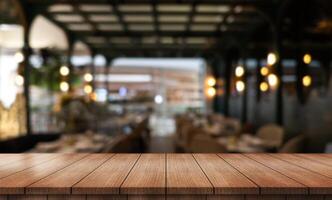 tömma trä- tabell topp med lampor bokeh på fläck restaurang bakgrund foto