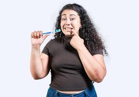 flicka lidande från gummi smärta innehav tandborste. ung kvinna med gingivit innehav tandborste isolerat. människor innehav tandborste med gummi problem foto