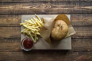 burger och franska frites på en trä- tabell. foto