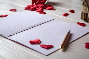 röd ljus, kärlek hjärtan och anteckningsbok på de tabell. skön bckground med kopia Plats. foto