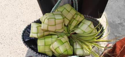 Ketupat eller ris klimp. en traditionell ris hölje tillverkad från ung kokos löv för matlagning ris såld i traditionell marknadsföra förberedelse för de eid al-fitr Semester för muslim foto