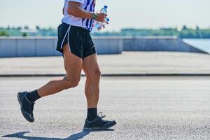 atletisk man joggning i sportkläder på stad väg foto