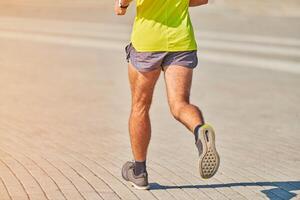 atletisk man joggning i sportkläder på stad väg foto