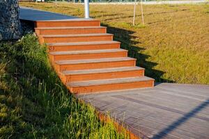 trä- trappa stad parkera, steg tillverkad av trä, styrelser på de väg, väg trottoar, skugga på de gräs, landskap design. foto