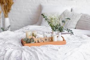 vacker heminredning med vita och beige toner, med drömfångare, torra blommor och en säng