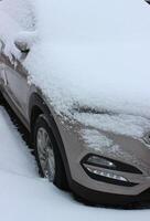 snö keps på en huva, vindskydd och sida spegel av fordon parkerad på asfalt stock Foto