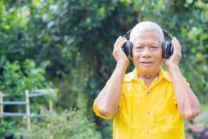 senior man lyssna musik från trådlös hörlurar foto