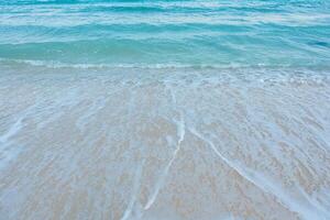 mjuk Vinka av blå hav på sandig strand. sommar semester i ö. klar azurblå vatten bakgrund. foto