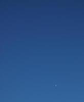 sista fjärdedel halv måne över blå himmel foto