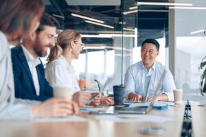 arbetslag av ung asiatisk affärsman arbetssätt och kommunicerar tillsammans i ett modern kontor foto