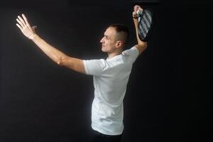 padel tennis spelare med racket i händer. paddla tennis, på en svart bakgrund. foto